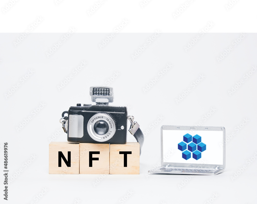 A miniature camera, laptop with blockchain, Ethereum symbol and NFT word.  A non-fungible token (NFT) is a non-interchangeable unit of data stored on a blockchain. Can sold and traded