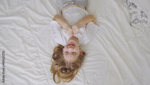 view top. a little girl laughs with tickling on the bed. games of children