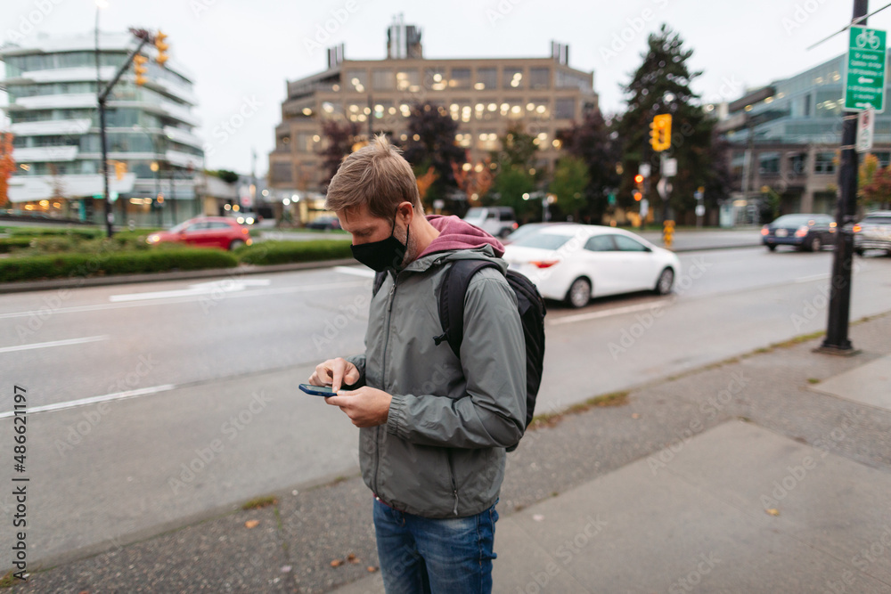 Man on street checking phone for ride. Man on street checking phone for ride.