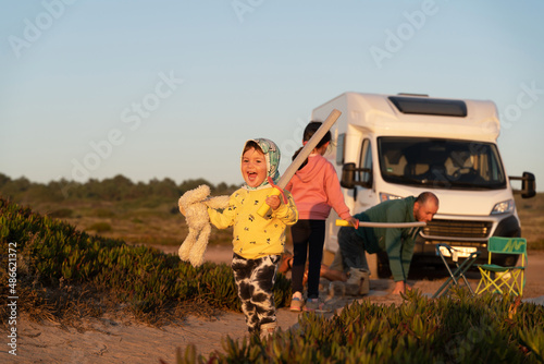 Kids playing outdoors around family motorhome