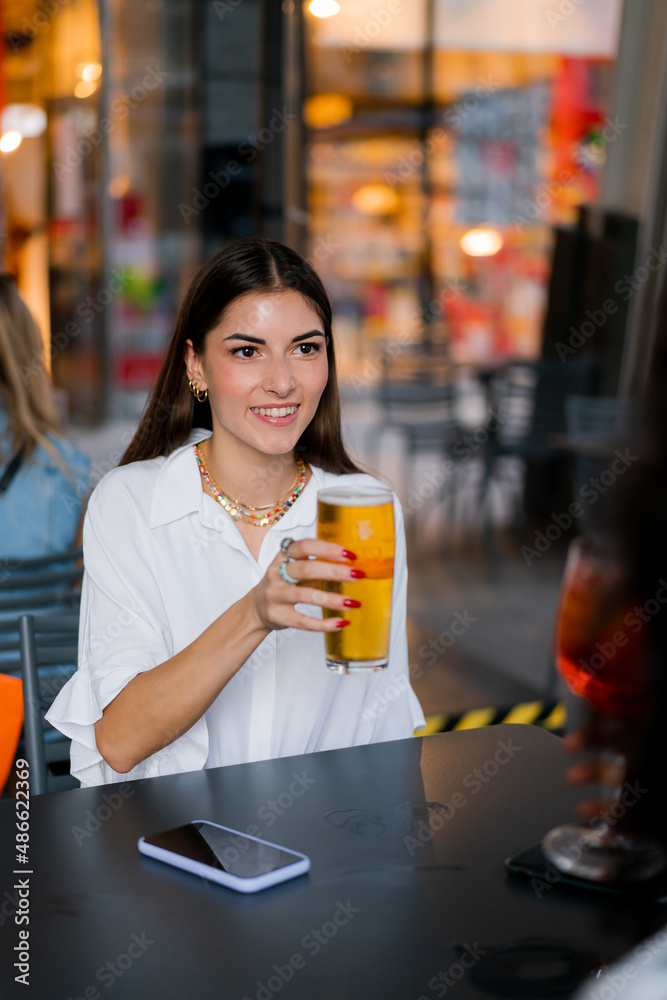 A woman drinks a beer in a bar A woman drinks a beer in a bar
