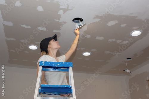 Kitchen Remodel Young Woman Installing Ceiling Light Landscape