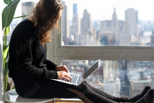 Woman typing on laptop computer photo