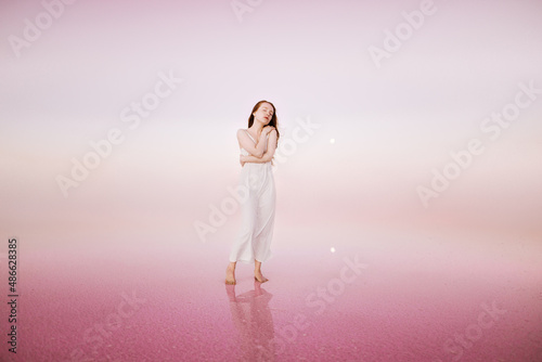 Read head woman in white dress on the pink background  photo