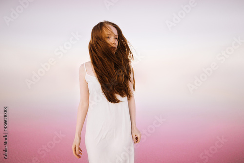 Beautiful woman in a white dress in the pink lagoon photo