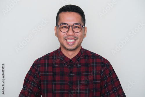 Closeup portrait of smiling adult Asian man wearing glasses photo