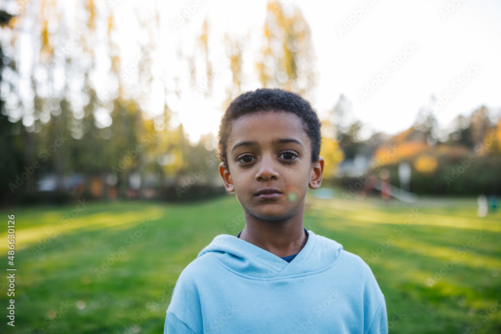 Thoughtful boy outside in grass Thoughtful boy outside in grass