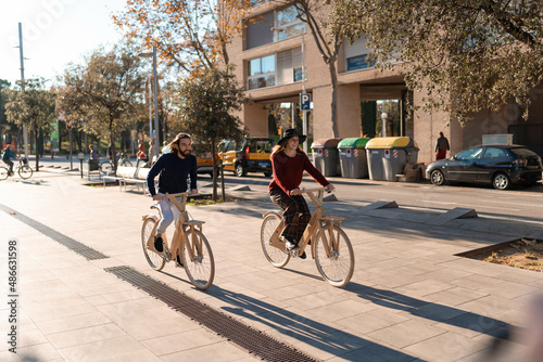 Friends riding wooden bicycles on city street