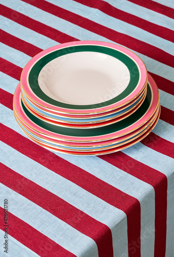 Stack of plates on striped tablecloth photo