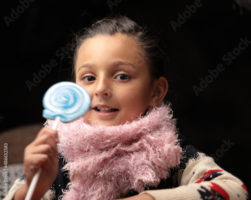 A baby girl with a candy