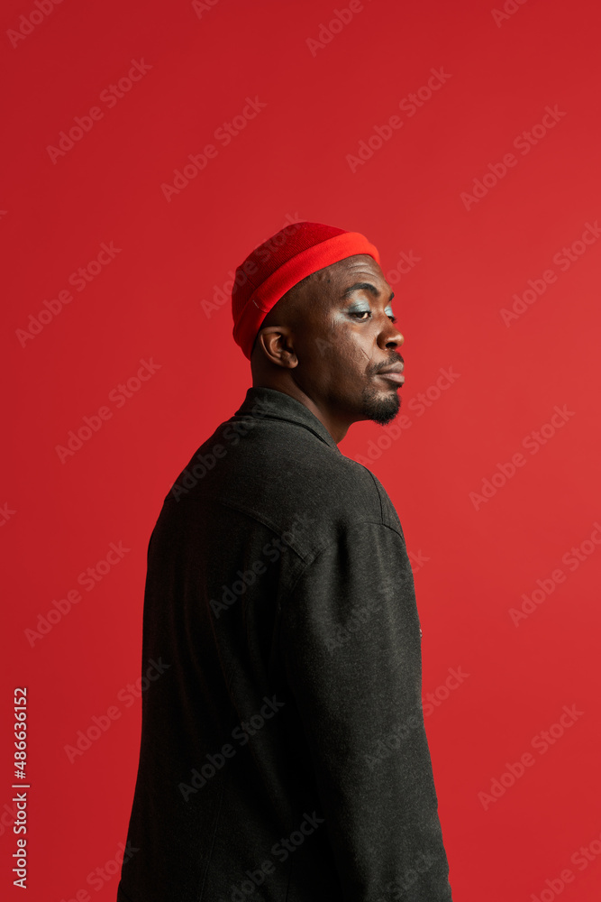 Trendy black man with makeup wearing bright hat Trendy black man with makeup wearing bright hat