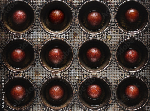 Indian Dessert Gulab Jamun in a Vintage Muffin Tin photo