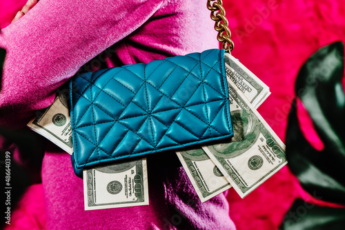 carries a blue purse full of fake dollar bills photo