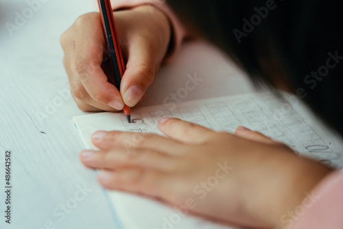 Child girl writing math numbers photo
