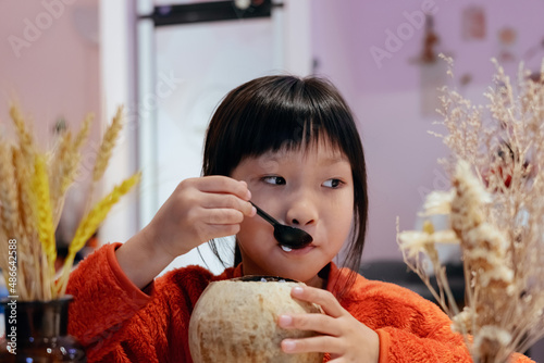 Child girl eating coconut dessert food