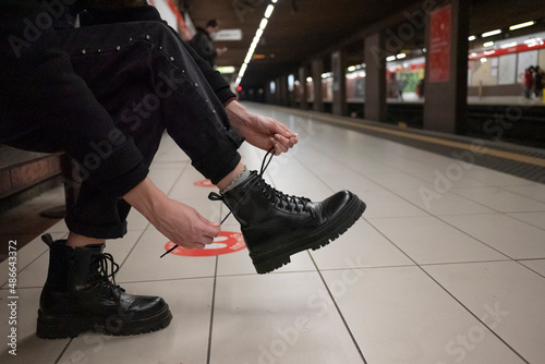 Woman ties boots in the subway. photo