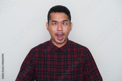 Closeup portrait of adult Asian man showing funny ugly face