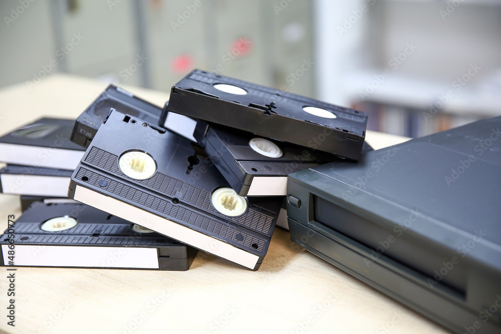 Pile of video cassette tape VHS old retro style stack concept of vintage electric and electronic appliances multimedia record player device old fashioned. Pile of video cassette tape VHS old retro style stack concept of vintage electric and electronic appliances multimedia record player device old fashioned.