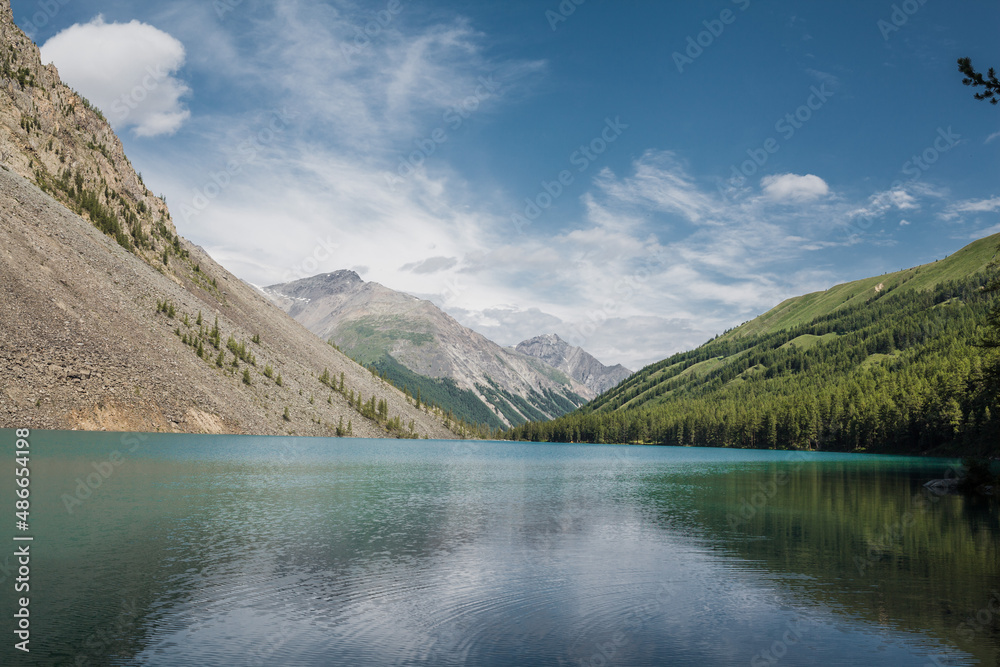 blue sky over a beautiful mountain lake in the forest between the hills