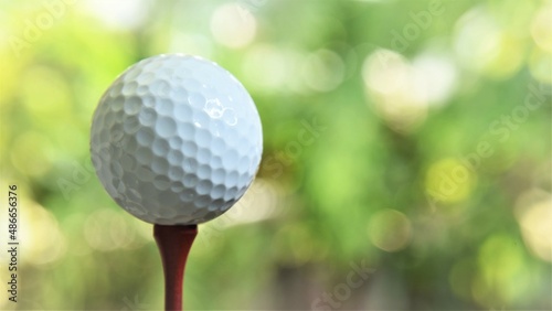 golf ball on tee green bokeh background