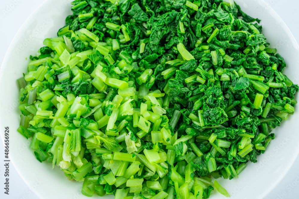 Boiled chopped radish seedlings on a white background