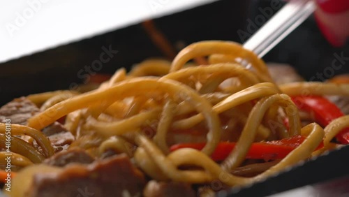beef with udon noodles in teriyaki sauce close-up. wok noodles
