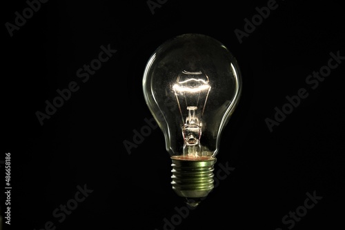 Canvas Print tungsten light bulb on black background