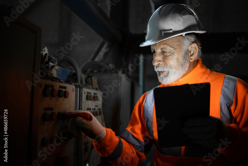 Industrial engineer electrician checking malfunction of voltage and electric installation of electrical cabinets in production factory. photo