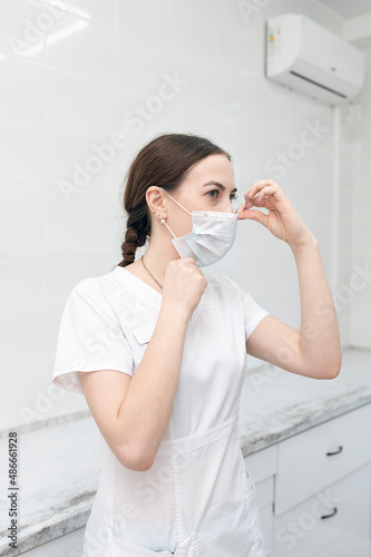 The dentist puts on a mask and prepares to examine the patient.