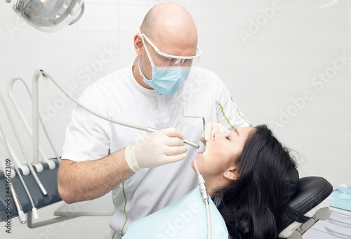 A Woman At A Dentist. Series of photos at a dentist's office. A beautiful woman sitting in a dentist's chair, having a dental procedure.