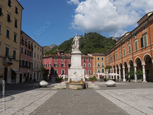 Alberica square in Carrara surrounded by colorful buildings and with the statue dedicated to Beatrice Este made of marble and the lion fountain in the center photo