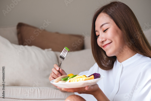 Obraz na plátně Portrait image of a young woman eating vegetables, Vegan, Clean food, dieting co