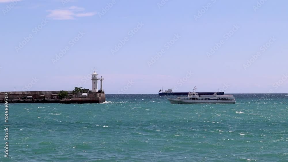 the ship is moving against the background of the Yalta Crimea lighthouse the ship is moving against the background of the Yalta Crimea lighthouse