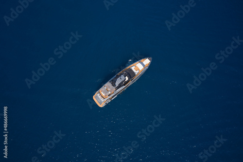 Big gray super boat on the water aerial view. Luxurious gray blue Mega yacht on dark water top view. Big yacht for millionaires in the sea drone view.