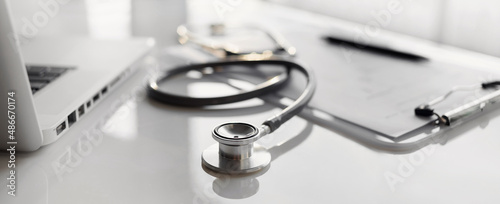 Doctor office desk panoramic banner, workplace of physician therapist with stethoscope in focus closeup, Health care, medicine, medical insurance concept.