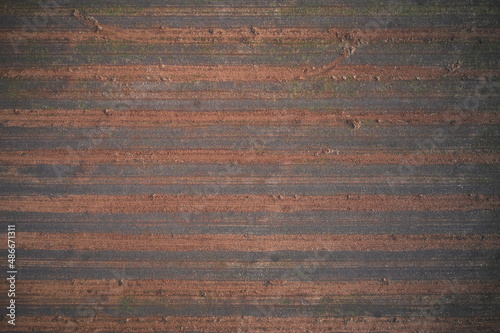 Texture of arable land top view. Winter texture plowed land drone view. Italian arable land in winter season top view. Striped texture brown red color aerial view. photo