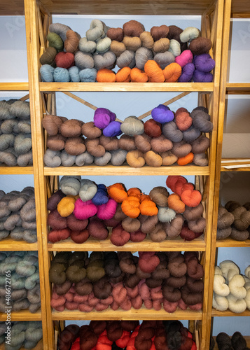 Fototapeta Naklejka Na Ścianę i Meble -  wool yarn threads, colored yarn skeins arranged on shelves, knitting as a hobby