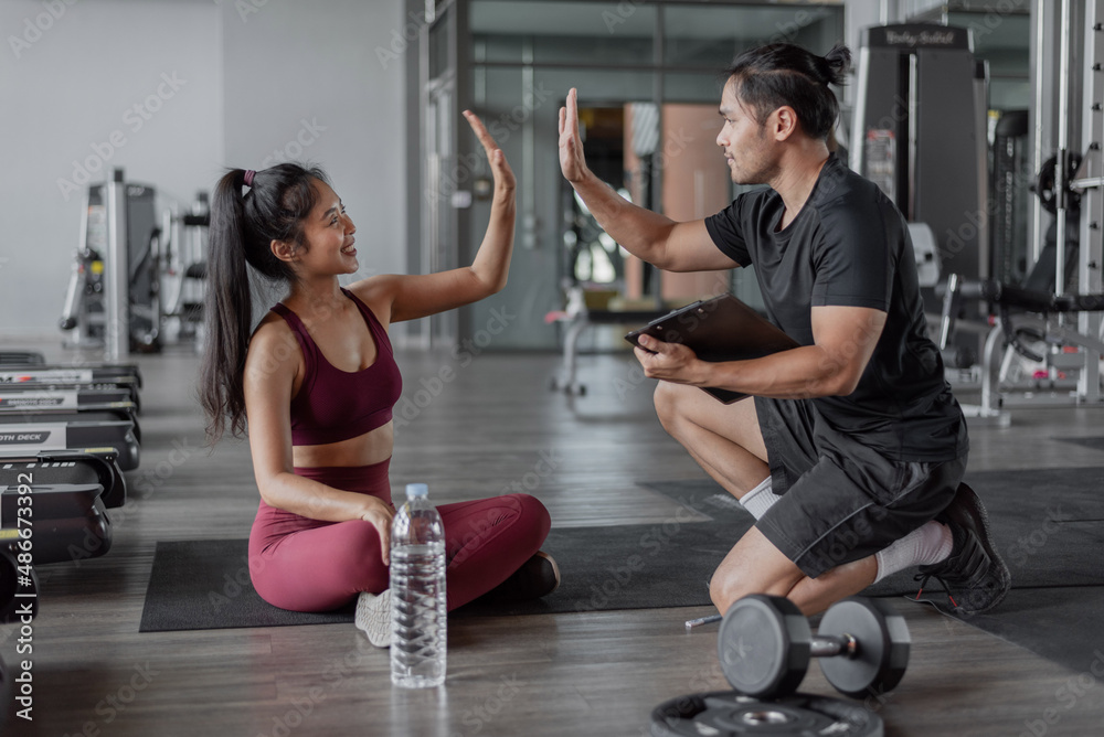 Asian woman exercise with personal trainer in gym. Healthy woman give me five with personal trainer. Asian woman exercise with personal trainer in gym. Healthy woman give me five with personal trainer.