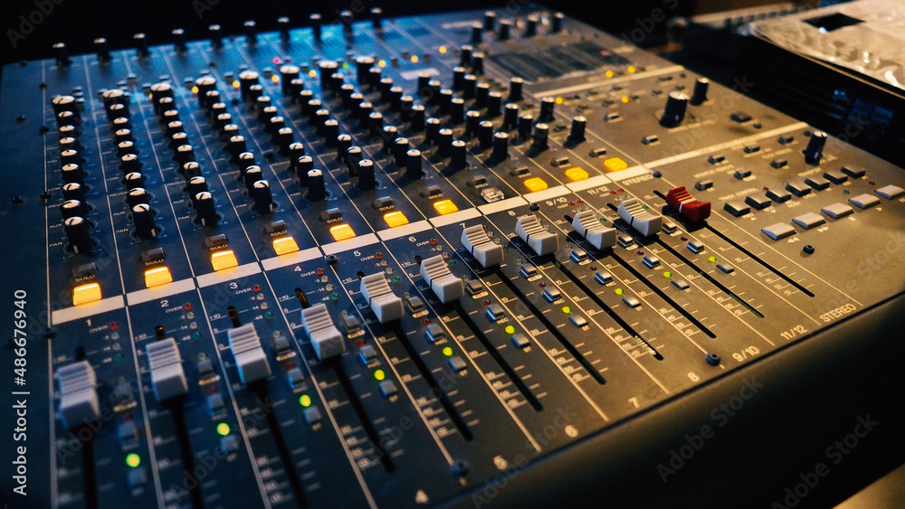 Analog audio sound mixer controller panel machine for work with digital recording and final mix with visual on filming video or movie production process in big studio.