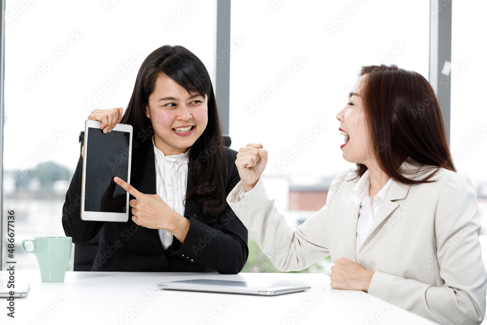 Two Asian professional successful friendly female businesswoman colleague in formal suit take coffee break have funny talking conversation and laughing together in company office with laptop computer Two Asian professional successful friendly female businesswoman colleague in formal suit take coffee break have funny talking conversation and laughing together in company office with laptop computer