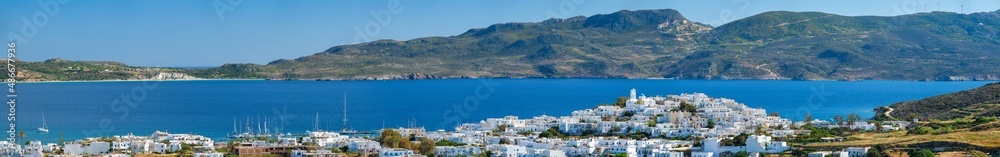 Panorama of Plaka village with traditional Greek church white painted Greek houses and ocean coast. Milos island, Greece