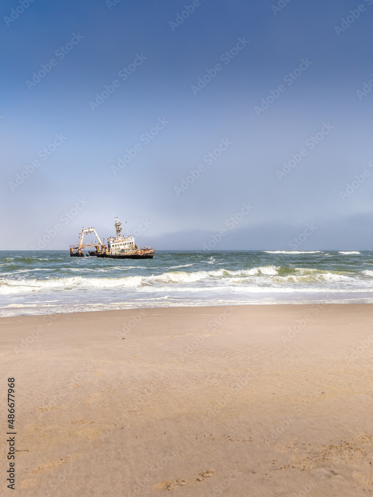 Abandoned shipwreck of the stranded Zeila vessel at the Skeleton Coast near Swakopmund in Namibia, Africa, with many cormorants sitting on the wreck.