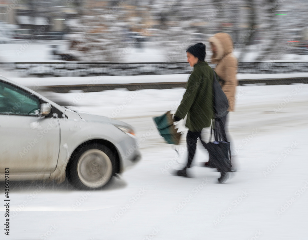 Dangerous situation on city road on zebra crossing in winter time. Intentional motion blur