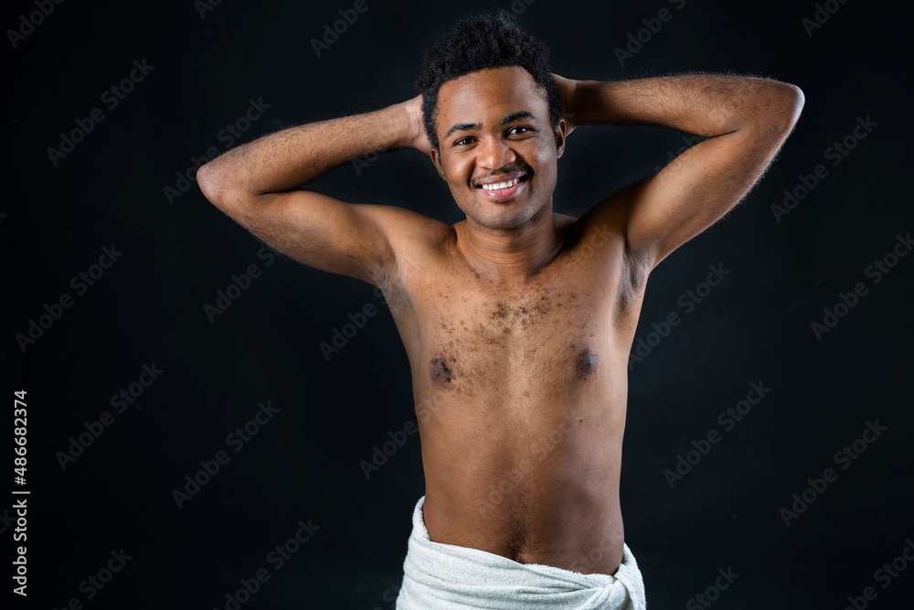 Fototapeta premium portrait of young african shirtless man on black background
