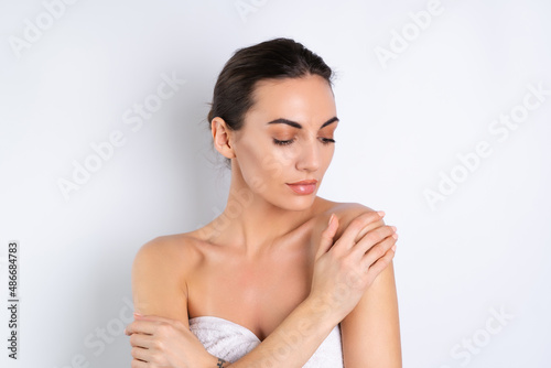 Close beauty portrait of a topless woman with perfect skin and natural make-up  plump nude lips  on a white background.