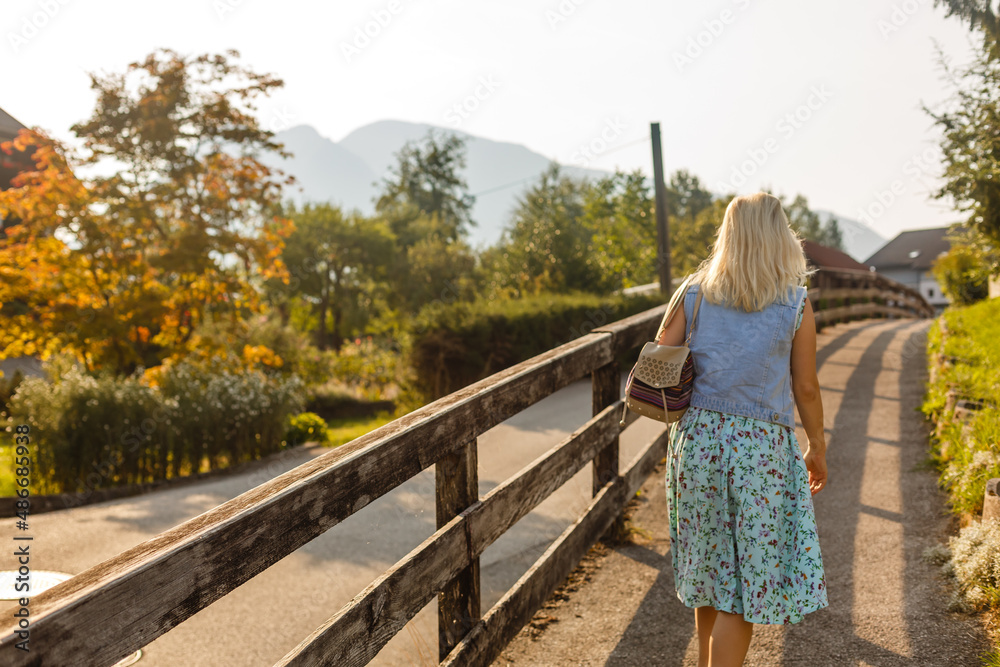 Young woman is standing by wooden houses. village in mountains. Travel, Lifestyle Concept. Alps, Europe.