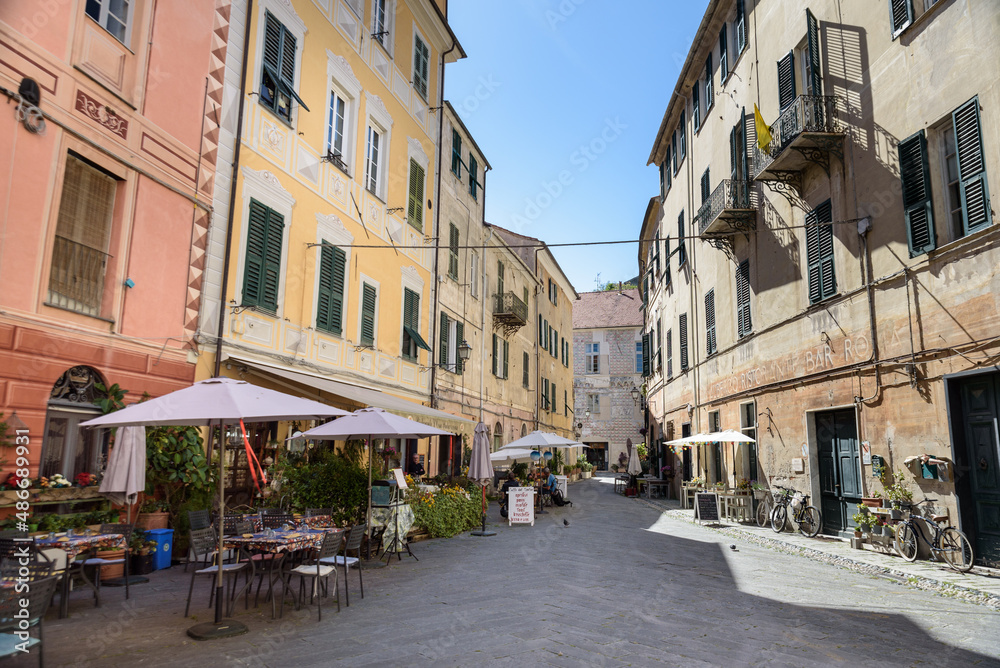 Finalborgo, Finale Ligure, Italy. May 5, 2021. View of Piazza Aicardi with outdoor tables of bars and restaurants.