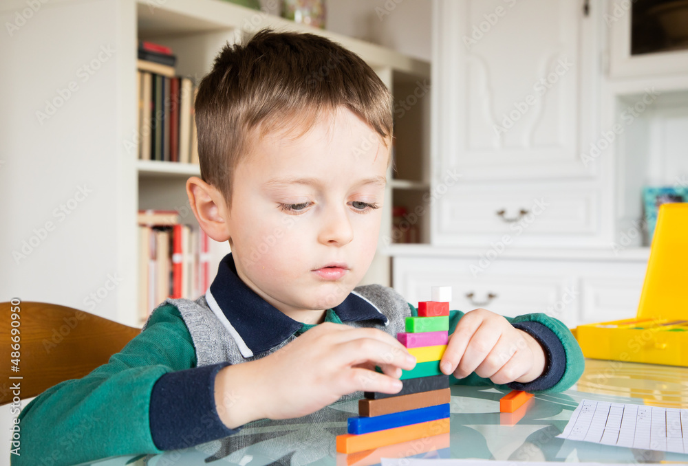 6 years old caucasian boy learning at home mathematics. Elementary age. 6 years old caucasian boy learning at home mathematics. Elementary age.