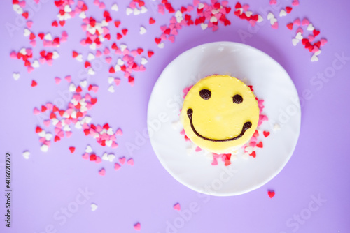 yellow cake emoji with small hearts on a purple background. Valentine's day and birthday concept photo