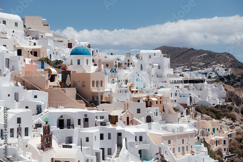 View of Oia town with church and blue dome in Santorini island in Greece. Summer vacation and holiday concept, luxury travel. Wonderful scenery, cruise ships and white architecture. Amazing landscape